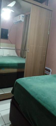 a room with two beds and a closet with a door at cris Gomes cop30 in Ananindeua