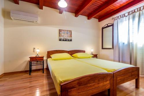 a bedroom with a large bed with yellow pillows at Vila Rici in Marčana