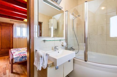 a white bathroom with a sink and a shower at Vila Rici in Marčana