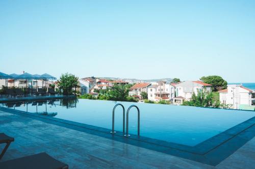 a view of a swimming pool with buildings in the background at Lemon Suites & Restaurant in Korucuk