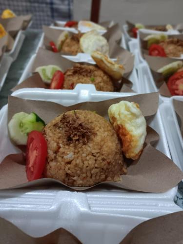 een bord met eten met gefrituurde gerechten en groenten bij Homestay Anggur in Bukittinggi