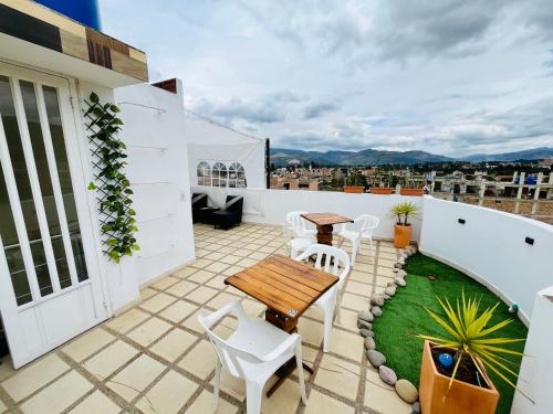 a patio with a wooden table and chairs on a roof at Hospedaje Edificio Alejandria in Sogamoso