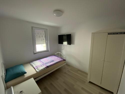 a small room with a bed and a window at WgCetin in Göppingen