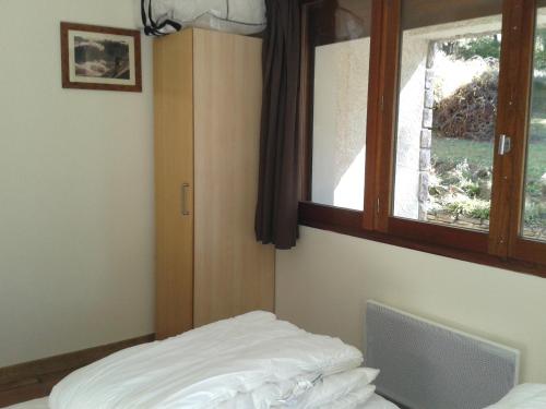 1 dormitorio con cama y ventana en Alpineaccomodation en Guillestre