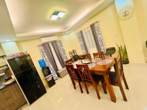 a kitchen and dining room with a table and a refrigerator at Unlock the Perfect Space for You in Pooc