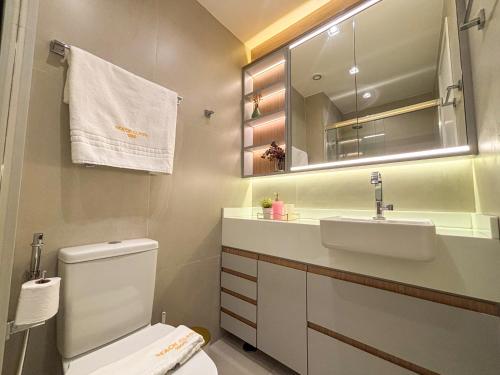 a bathroom with a toilet and a sink and a mirror at Studio 600m da praia in Fortaleza