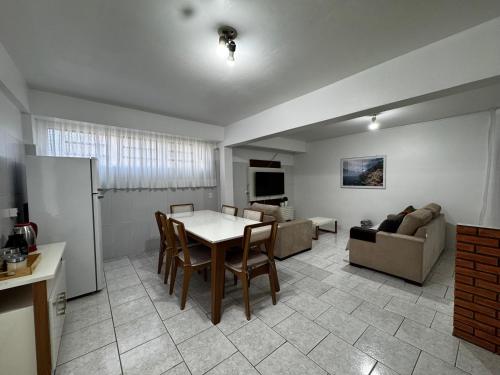 un soggiorno con un tavolo e un divano di Apartamento novo e aconchegante a Bento Gonçalves