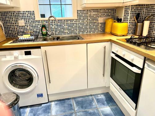 a kitchen with a washing machine and a sink at Marina Waves Apartment- Brighton, free parking, patio, ground-floor holiday home, one bedroom, sleeps 3 in Brighton & Hove