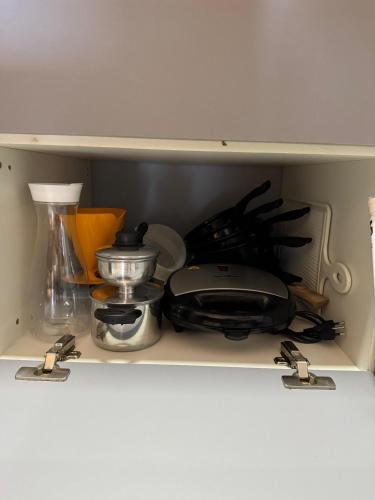 a shelf with various kitchen utensils on it at Flat 706 próximo à praia - Condomínio Biarritz in São Luís