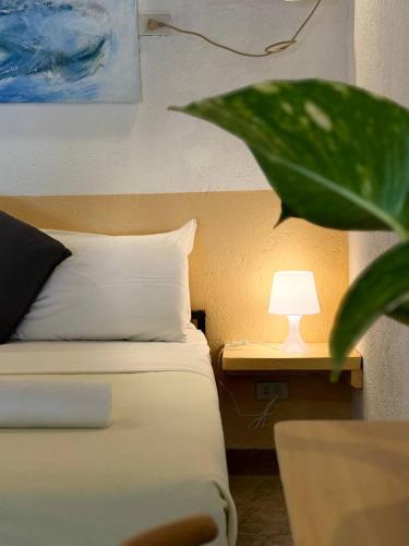 a bedroom with a bed with a lamp on a table at Lazy Dog Bed & Breakfast in Boracay