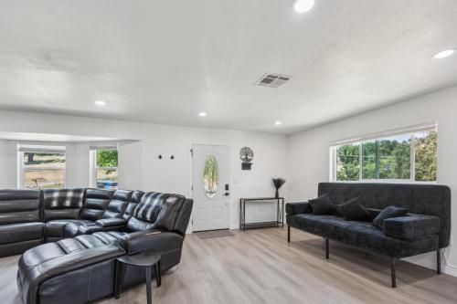 a living room with two leather couches and a tv at Desert Mountain Escape with Private Hot Tub home in Tehachapi