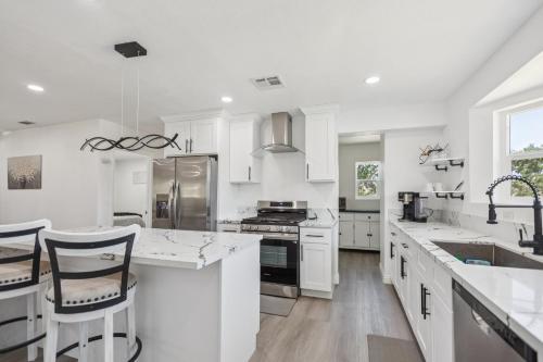 a white kitchen with white counter tops and appliances at Desert Mountain Escape with Private Hot Tub home in Tehachapi