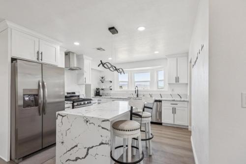 a white kitchen with marble counter tops and stainless steel appliances at Desert Mountain Escape with Private Hot Tub home in Tehachapi
