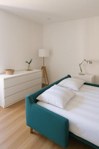 une chambre avec un lit bleu et blanc et un bureau dans l'établissement Le Nid Marin - studio cosy à Lorient, à Lorient