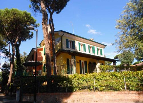 a yellow house with a tree in front of it at Holiday Homes in Rosolina Mare 24977 in Rosolina Mare