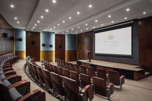 a lecture hall with a podium and a screen at Bay La Sun Hotel and Marina - Emaar King Abdullah Economic City in King Abdullah Economic City
