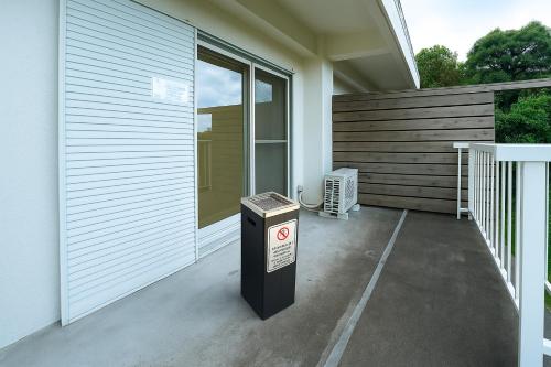 a trash can sitting outside of a house at 貸切温泉宿 Shiny inn Kirishimaシャイニーイン霧島 in Kirishima