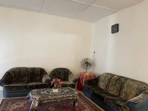 a living room with two couches and a table at RH Homestay Mentakab-Temerloh. in Mentekab