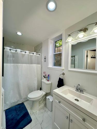 a white bathroom with a toilet and a sink at BP STAYS - Hotel-Style, No Host, Professionally Managed ID280 in Jersey City