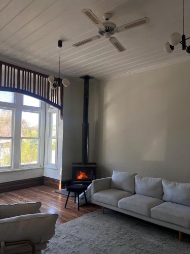a living room with a couch and a fireplace at Charming 100 year old Villa in Te Kuiti
