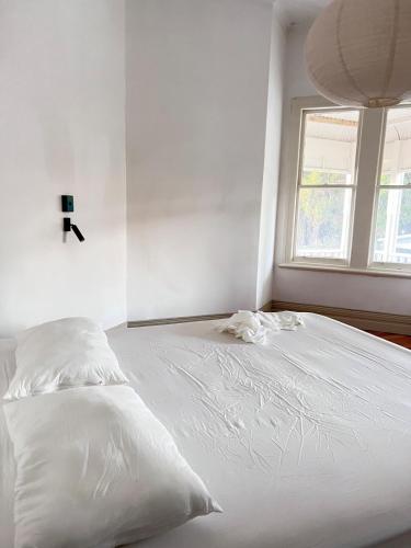 a white bed in a room with a window at Charming 100 year old Villa in Te Kuiti