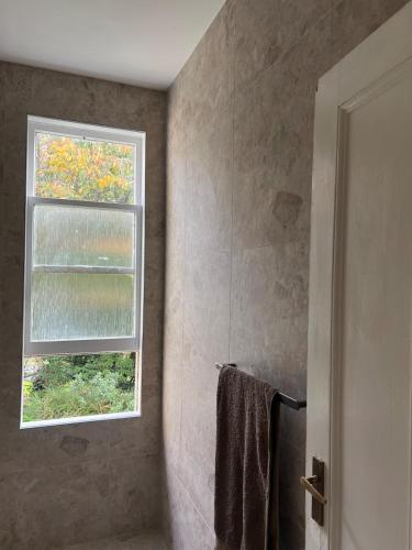 a bathroom with a window and a towel at Charming 100 year old Villa in Te Kuiti