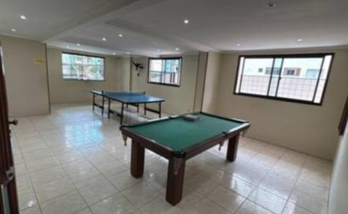 two ping pong tables in a room with windows at Apartamento com varanda in Samaritá
