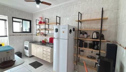 a kitchen with a white refrigerator in a room at Apartamento com varanda in Samaritá