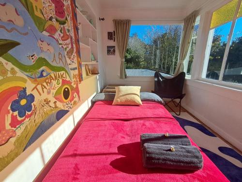 a bedroom with a large bed with a pink blanket at Sunrays Stay - Stylish Retreat in New Plymouth