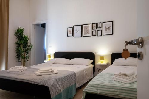 two beds in a bedroom with towels on them at Vacanze Cisternone Livorno centro in Livorno