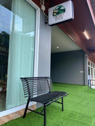 a black bench sitting in front of a building at Friendlyhostel in Khao Sok