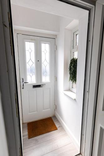 a hallway with a white door and a window at 4 Bedroom House in Wolverhampton Sleeps 8 Ideal for Contractors in Fallings Park