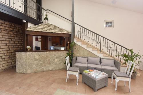 ein Wohnzimmer mit einer Couch und einem Tisch und einer Treppe in der Unterkunft Pansion Karoca in Vodice