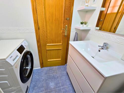 a bathroom with a washing machine and a sink at Sun & Playa 16 in Dehesa de Campoamor