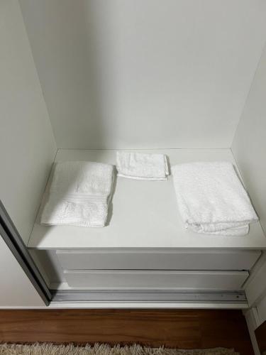a white bed with two white towels on it at Nossa casa, nosso lar in Belo Horizonte