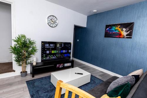 a living room with a couch and a tv at 4 Bedroom House in Wolverhampton Sleeps 8 Ideal for Contractors in Fallings Park