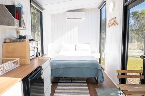 a bedroom with a bed in a kitchen with a window at Sweet Retreat by Tiny Away in Bundaberg