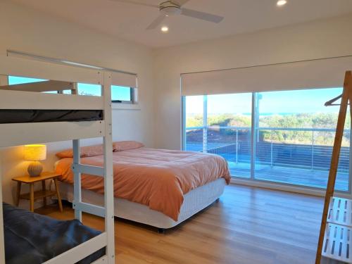 a bedroom with a bunk bed and a large window at 63 By The Sea in Wauraltee