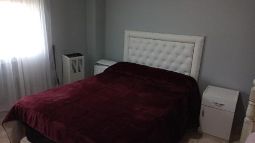 Un dormitorio con una cama grande y una ventana. en Confortable apartmento, en Bahía Blanca