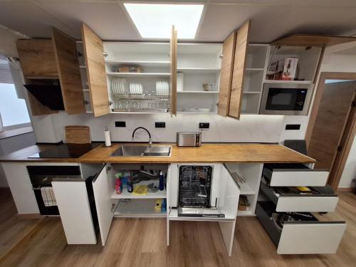 eine Küche mit weißen Schränken und einer Arbeitsplatte in der Unterkunft Piso Burjassot - Valencia in Burjasot