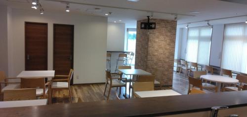 Habitación con mesas, sillas y pared de ladrillo. en バンデホテル in なんば, en Osaka
