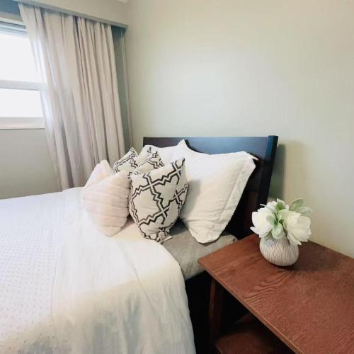 a bedroom with a bed with pillows and a table at Nest in the Orchard--cozy room in Toronto