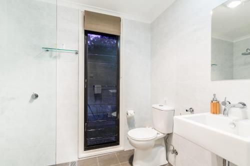 a bathroom with a toilet and a sink and a shower at Goosewing Cottage in Mount View