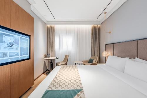 a hotel room with a bed and a flat screen tv at Yitel Premium Shanghai Jing'an Temple in Shanghai