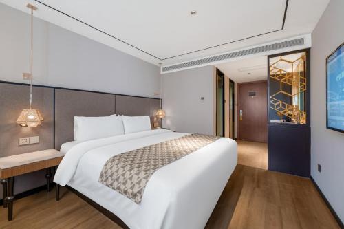 a bedroom with a large white bed and a desk at Yitel Premium Shanghai Jing'an Temple in Shanghai
