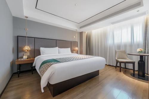 a bedroom with a large bed and a desk at Yitel Premium Shanghai Jing'an Temple in Shanghai