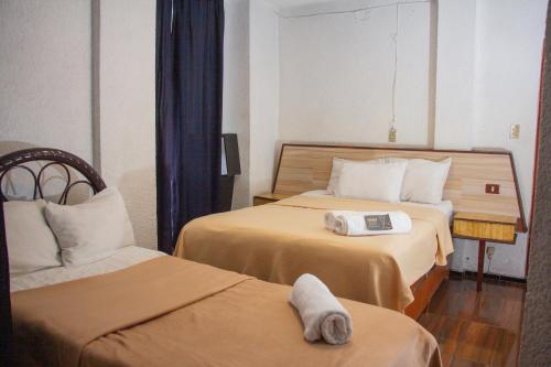 a hotel room with two beds with towels on them at Hotel Diamantes Orizaba Boutique in Orizaba