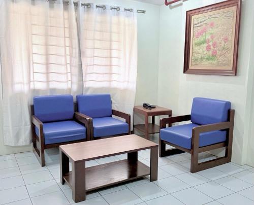 a waiting room with two blue chairs and a table at Joyce Apartelle San Juan in Manila
