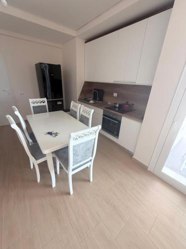 Polisi i Vogëlにあるpalmera apartamentの部屋にテーブルと椅子のあるキッチン