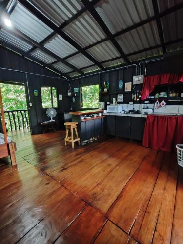 a large room with a wooden floor and a kitchen at Cabaña blue jeans in San Ramón